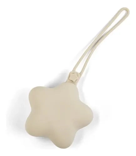 Guarda chupetes color crema con cuerpo de estrella y tira larga, visto sobre fondo blanco.