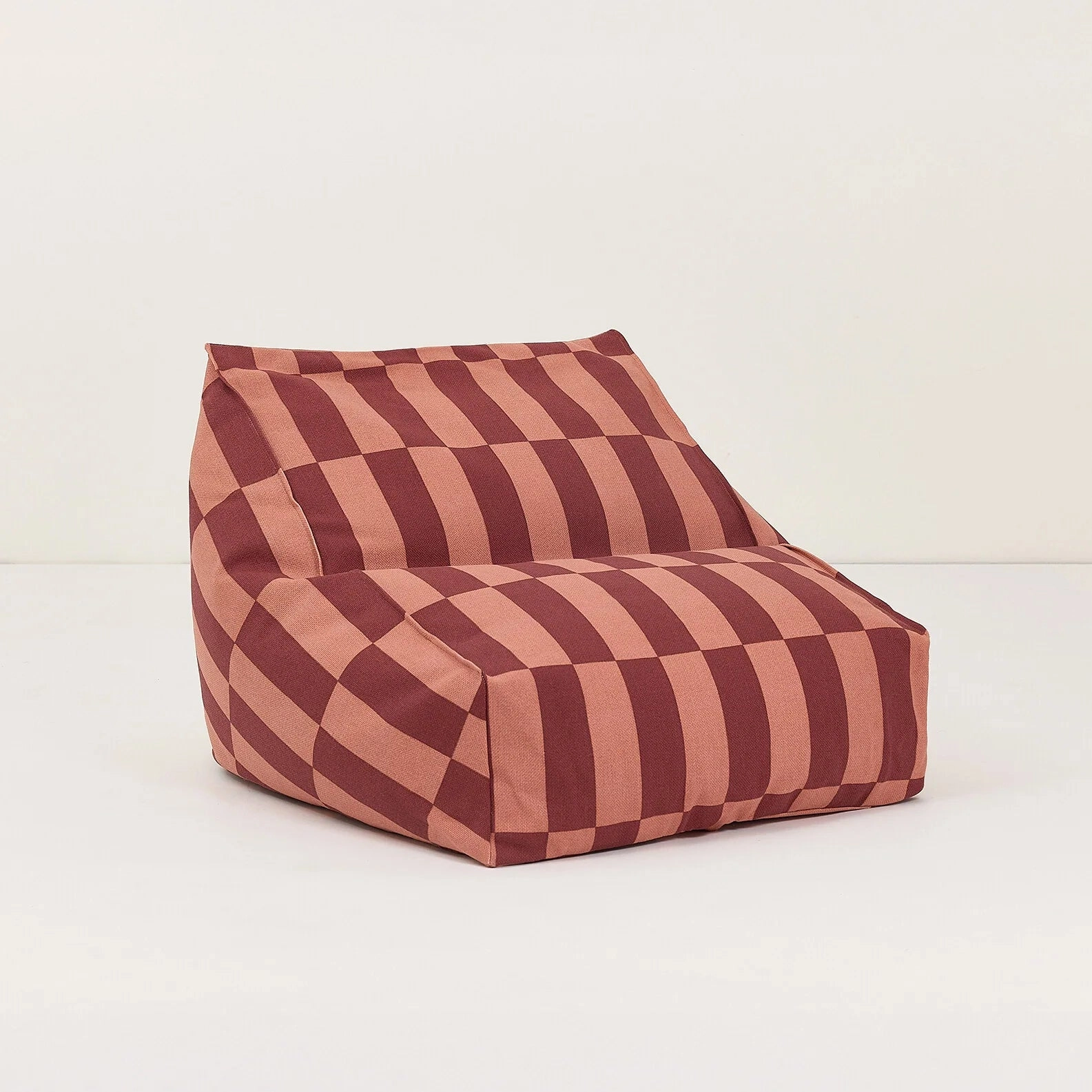 Pouf sillón Vibes de cuadros rojizos, visto de frente y de lado sobre fondo claro.