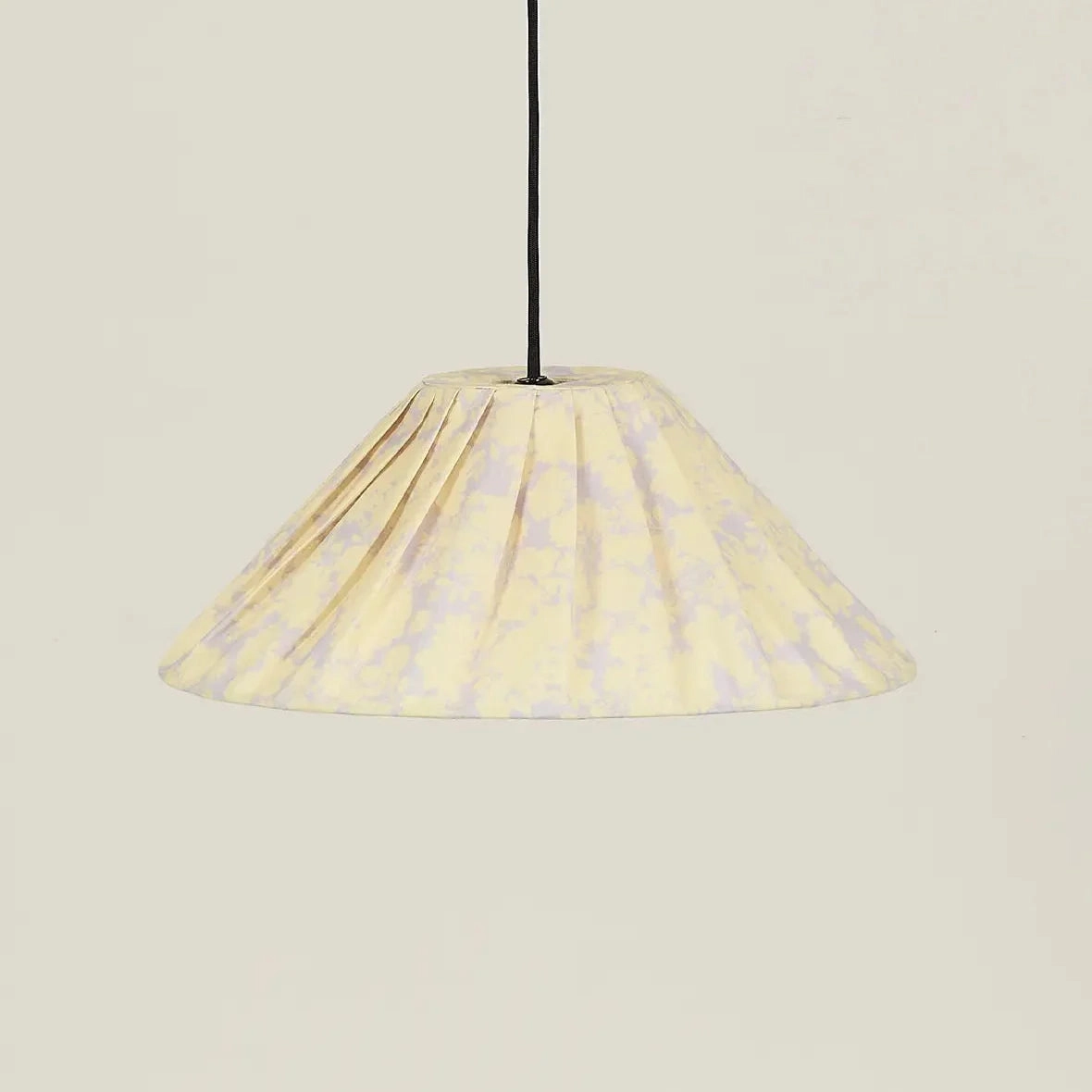 Lámpara colgante plisada con estampado amarillo, apagada y vista de frente.