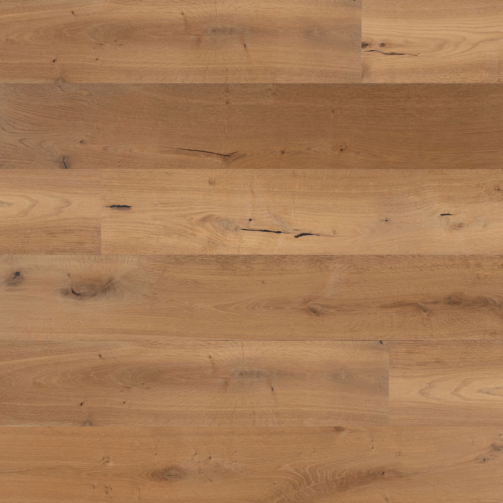 Piso de madera instalado, visto desde arriba, con tablas en tonos cálidos y vetas marcadas.